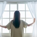 朝日が差し込む窓辺で穏やかな時間を過ごす女性｜乳がんの原因を考えすぎないために