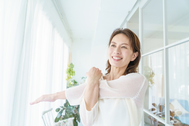肩まわりを無理のない範囲でやさしくストレッチする女性