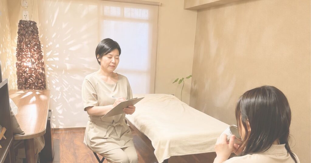 乳がん術後の痛みや身体の悩みについて女性から話を聞く理学療法士