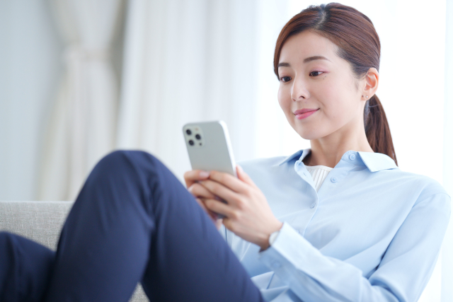 乳がん術後に不安からスマートフォンで情報を検索する女性