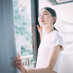 窓辺でこれからの人生について考えるがんのサバイバー女性