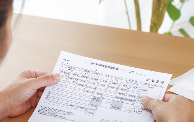 医療費領収書を見る女性