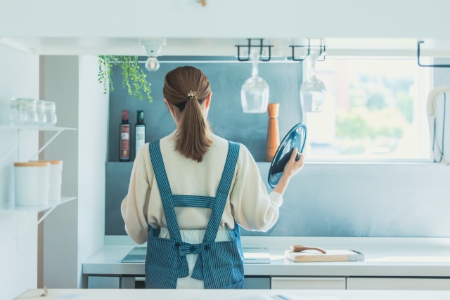 キッチンで家事をする40代の女性
