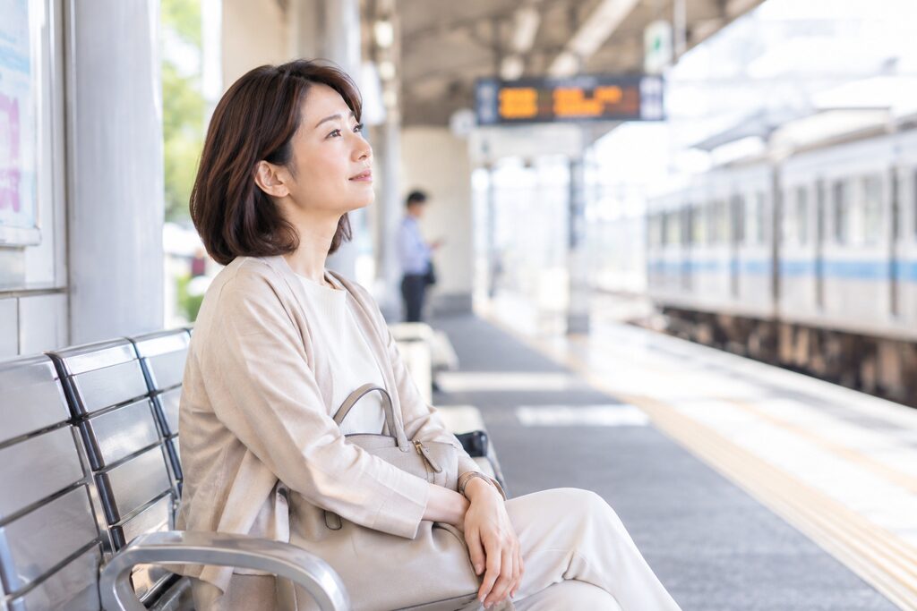 駅のベンチで少し休んでいる女性