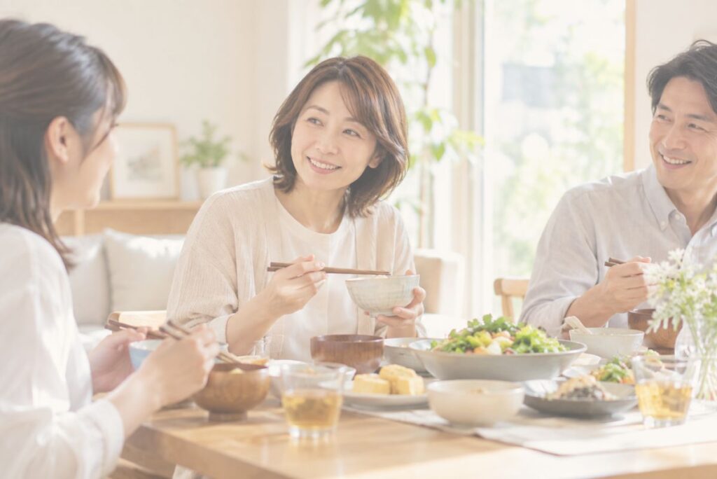 明るい自宅のリビングで家族と穏やかに食事を楽しむ女性