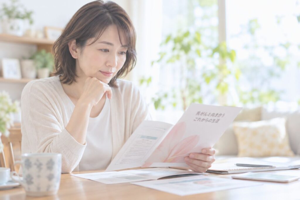 自宅で乳がん治療に関する資料を読み、考える女性